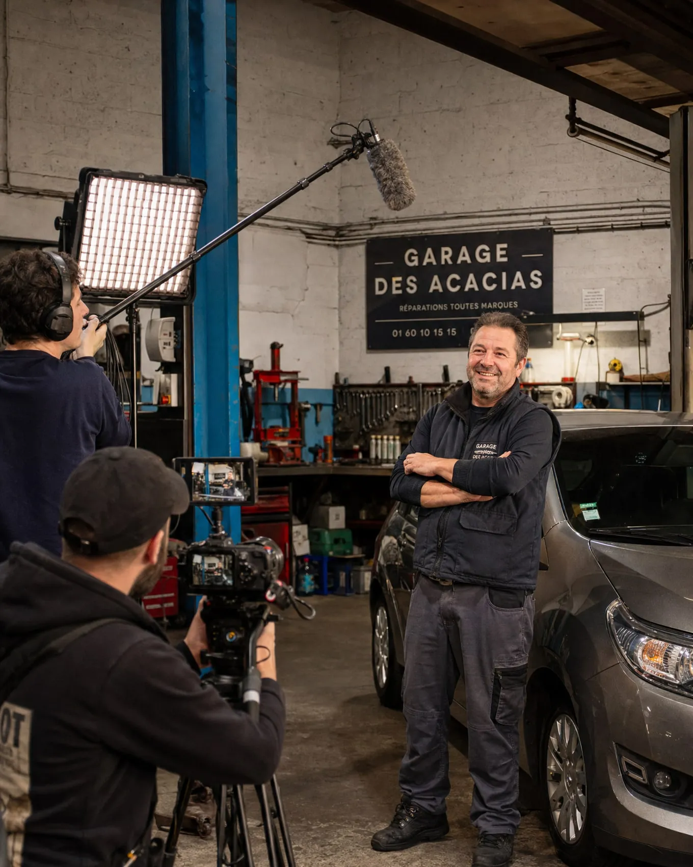 Équipe de tournage filmant un artisan garagiste dans son atelier